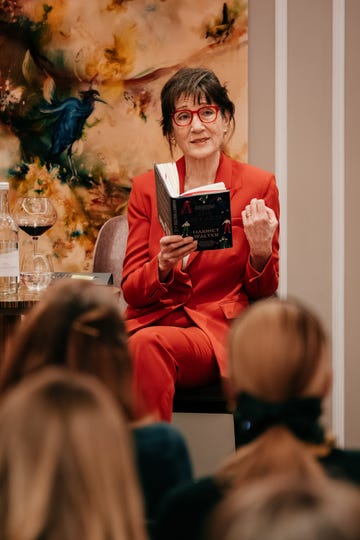 author reading a book during an event