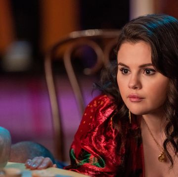 selena gomez in character for only murders in the building, she looks to the left and wears a red dress