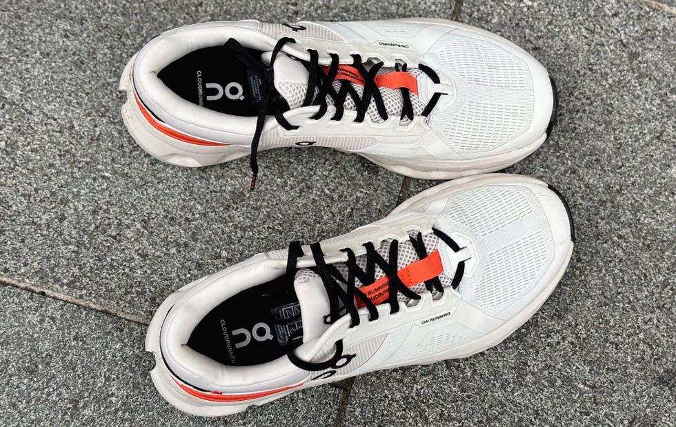 top view of a pair of white and orange running shoes