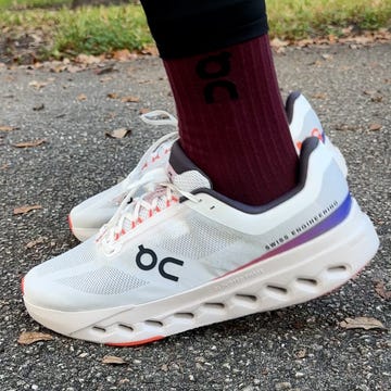 sport shoes paired with a maroon sock positioned on a paved surface