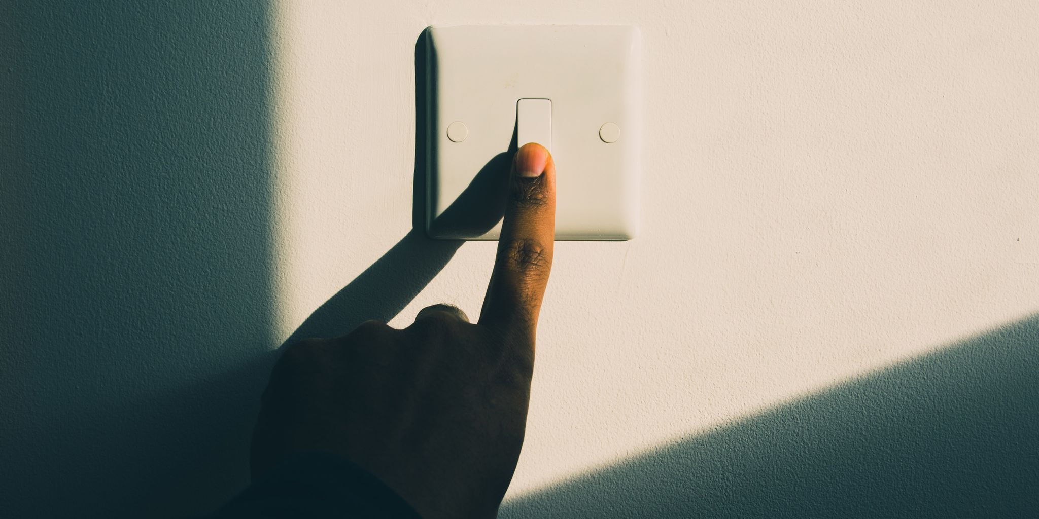 a woman's hand turning on a light switch