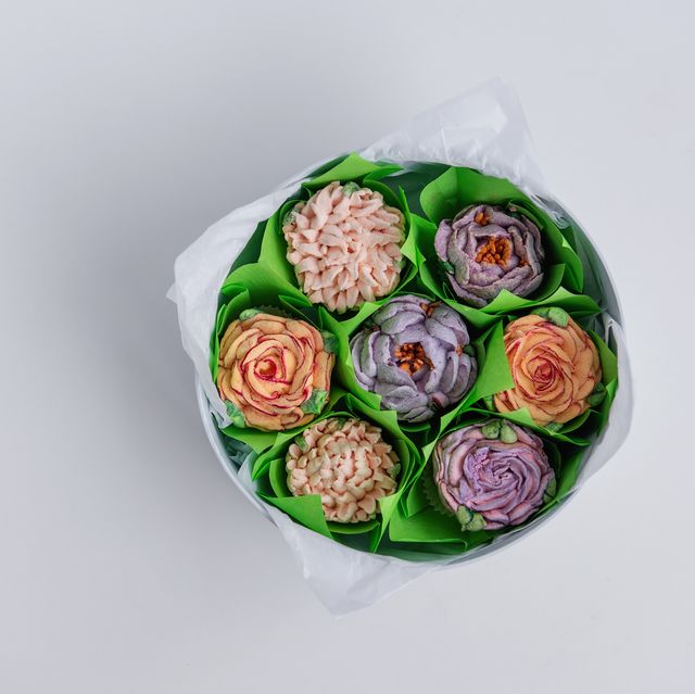 on white isolated background lies round gift box with sweet marshmallow flowers. hand natural work