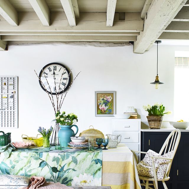 a dining room decorated with spring accessories including at table cloth and fresh flowers