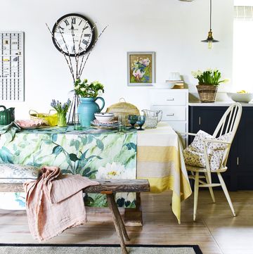a dining room decorated with spring accessories including at table cloth and fresh flowers