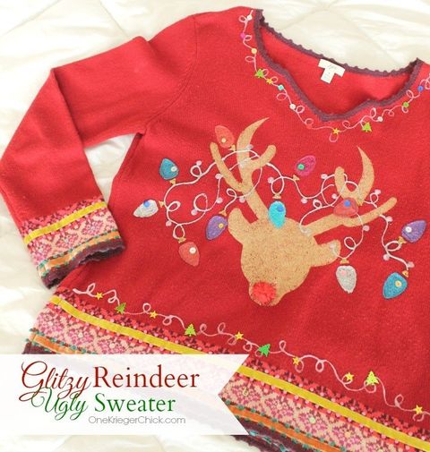 red christmas sweater with a reindeer head painted on the front with multi colored christmas lights painted around the antlers