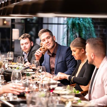 a group of people sitting around a table with glasses of wine