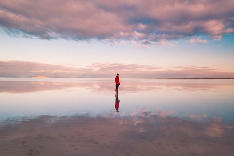 one person standing on the flooded bonneville salt flats, utah, united states of america