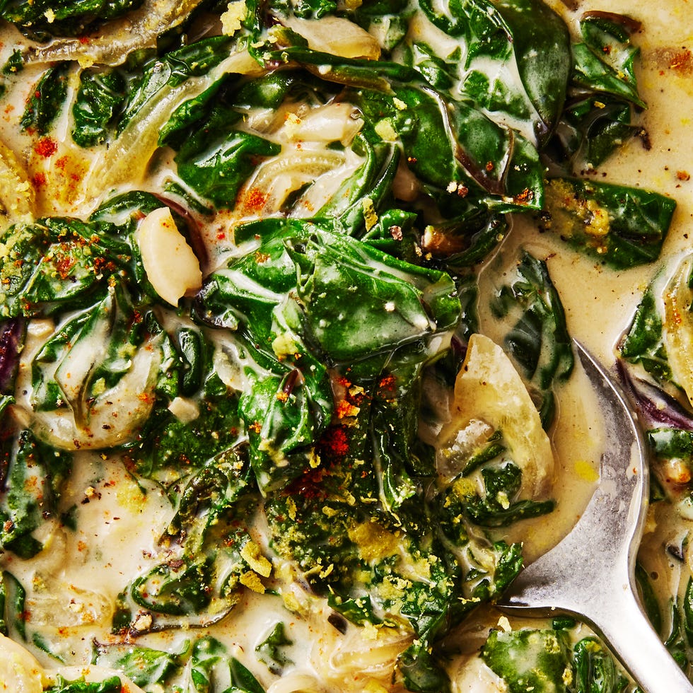 greens and onions in a creamy sauce in a pan