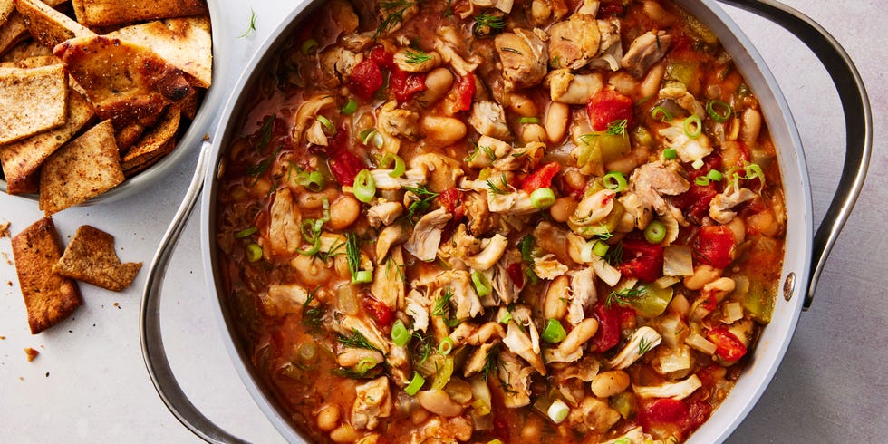 chili in a bowl with chicken, tomatoes, and green onions