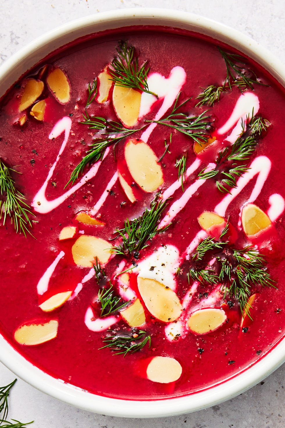 One Pot Harissa Beet Soup one pot harissa beet soup in a white bowl topped with almonds, herbs, and cream