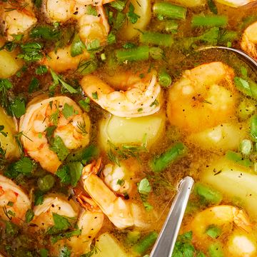 shrimp potato soup in a pot topped with herbs