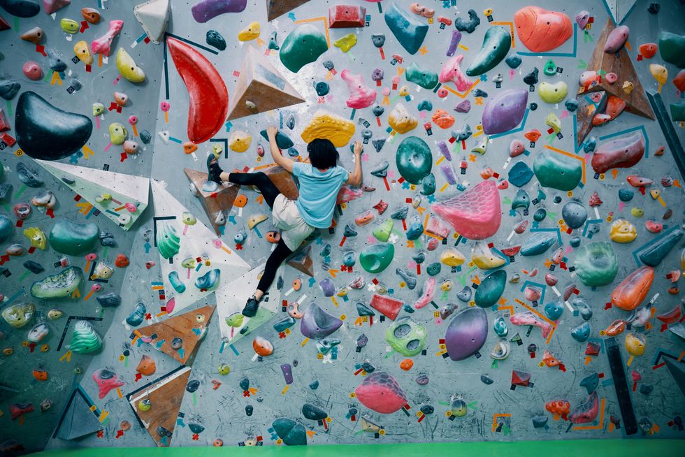 One teenage girl climbing a bouldering wall at a rock climbing gym