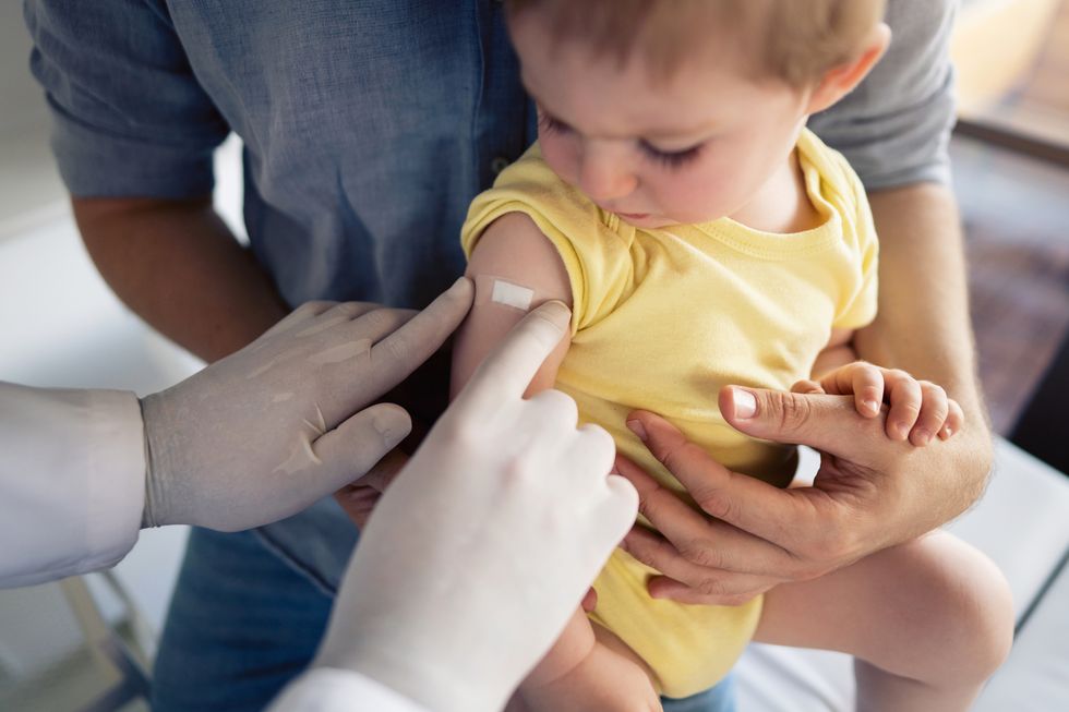 bebé con una tirita después de ser vacunado
