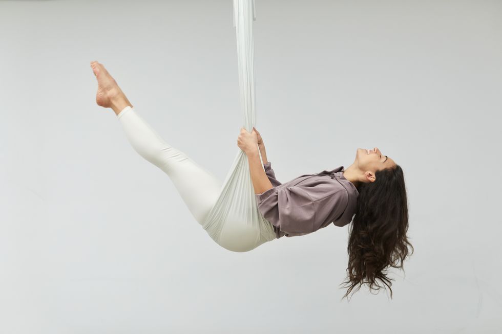 one woman practicing aerial yoga