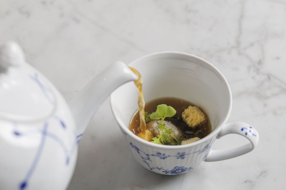 a tea cup with a plant in it