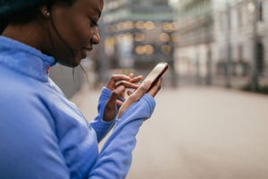 een vrouw kijkt tijdens het trainen op haar telefoon