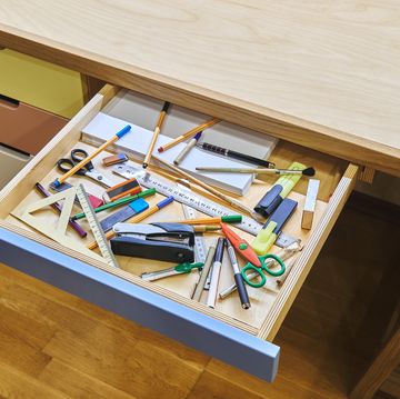 open desk drawer with unsorted various school supplies