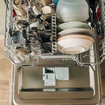 open dishwasher with clean dishes in the white kitchen