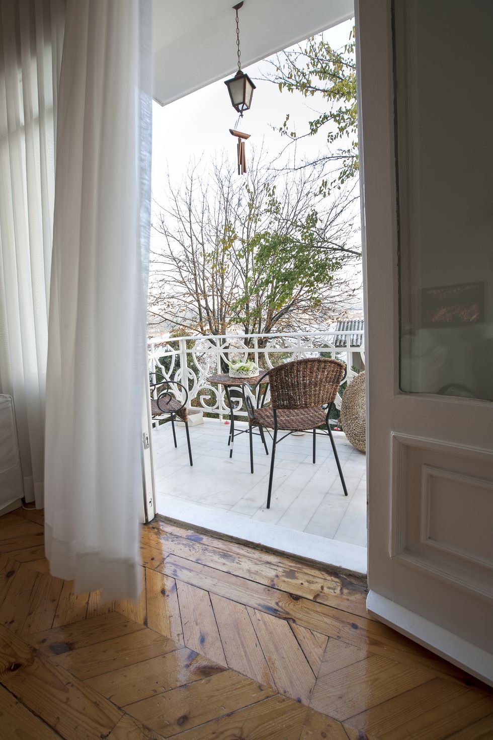 open door with transparent white curtains drapery with view on terrace
