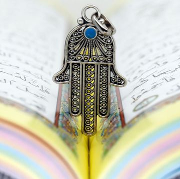 open holy quran with hamsa or hand of fatima faith and religion