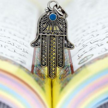 open holy quran with hamsa or hand of fatima faith and religion