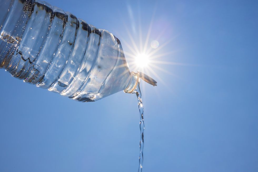 open water bottle with blue sky and bright sun