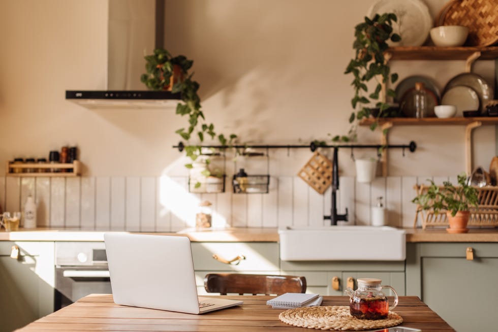 opened laptop notebook with white screen on wooden table against window at home, mock up