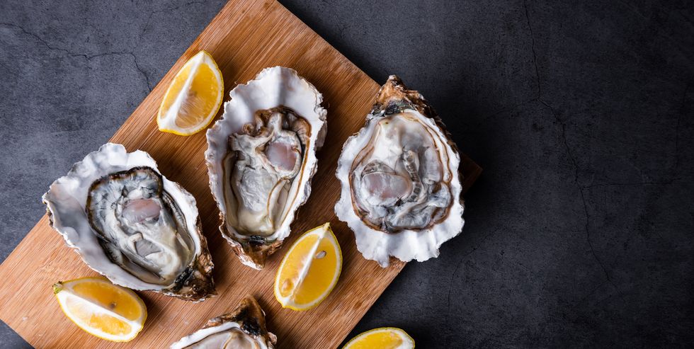 opened oysters on table with lemon