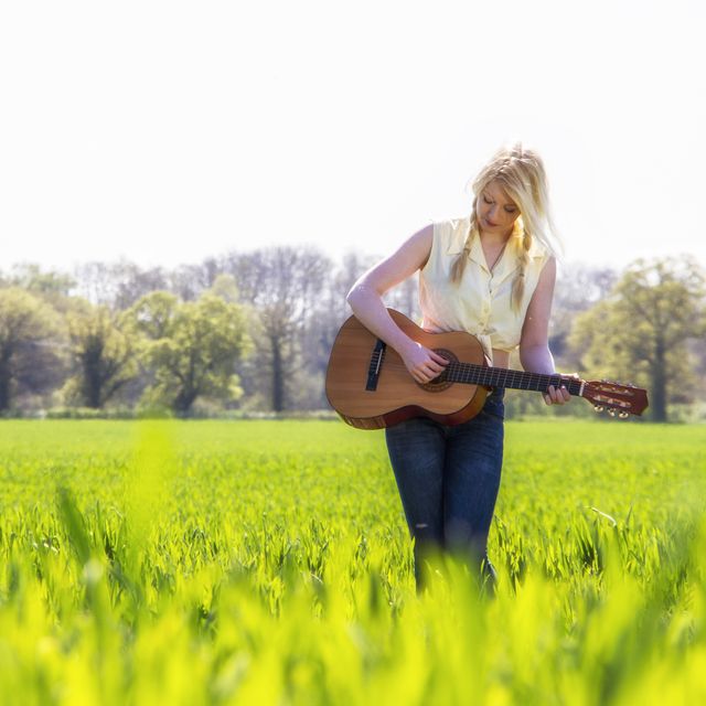 female country singer in grass field