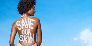 Black woman in bathing suit with sunscreen