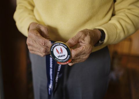 skip grant holds a medal that he won in the 500 meter race in the 2018 masters indoor usatf chapionship, on april 2, 2021