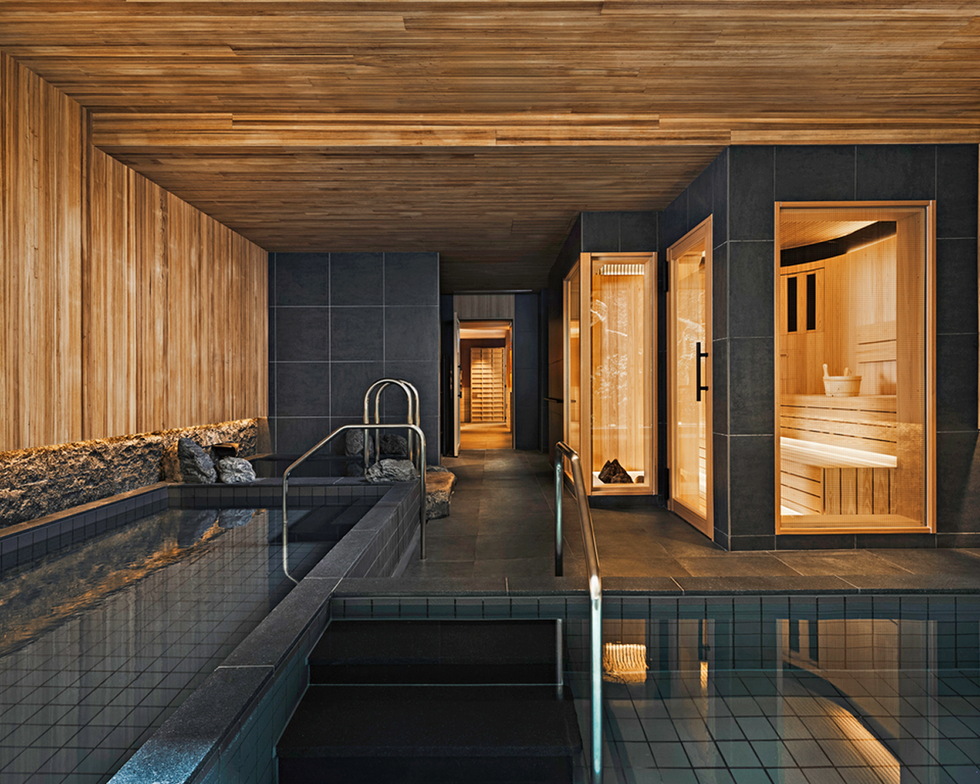 interior view of a modern spa featuring a pool and saunas