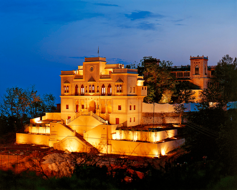 illuminated architectural structure with steps and surrounding trees at twilight