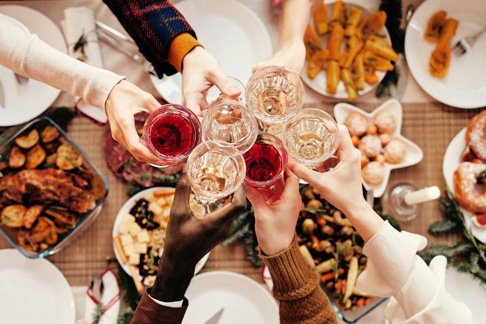 top view background of people raising glasses over festive dinner table while celebrating christmas with friends and family, copy space