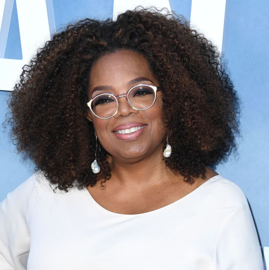 oprah winfrey smiles for camera at premiere event