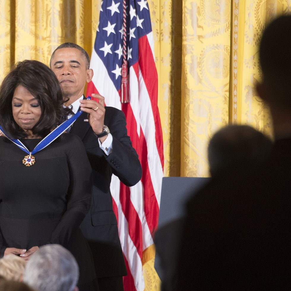 president barack obama places medal around neck of oprah winfrey