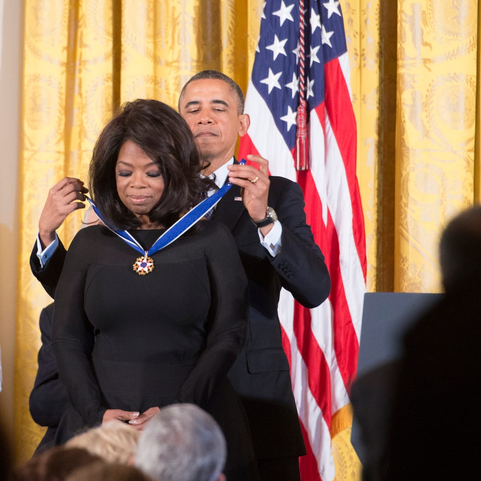 president barack obama places medal around neck of oprah winfrey