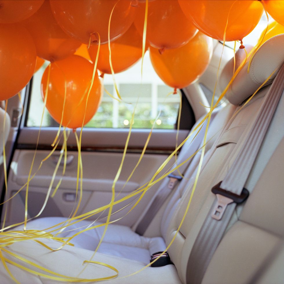 quarantine birthday - Orange balloons in back seat of car