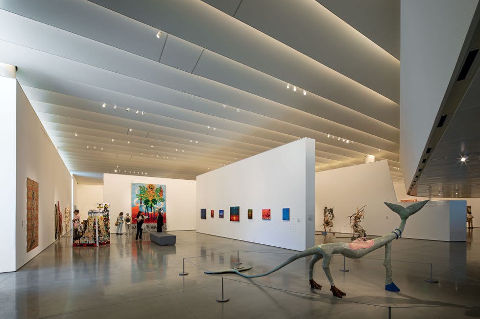 orange county museum of art gallery, which are illuminated by lights hidden within ceiling louvers, while discreet spotlights shine on the art