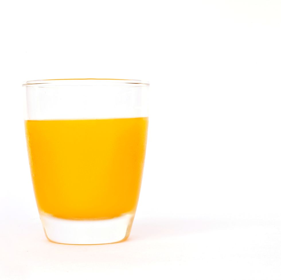 orange juice in glass against white background