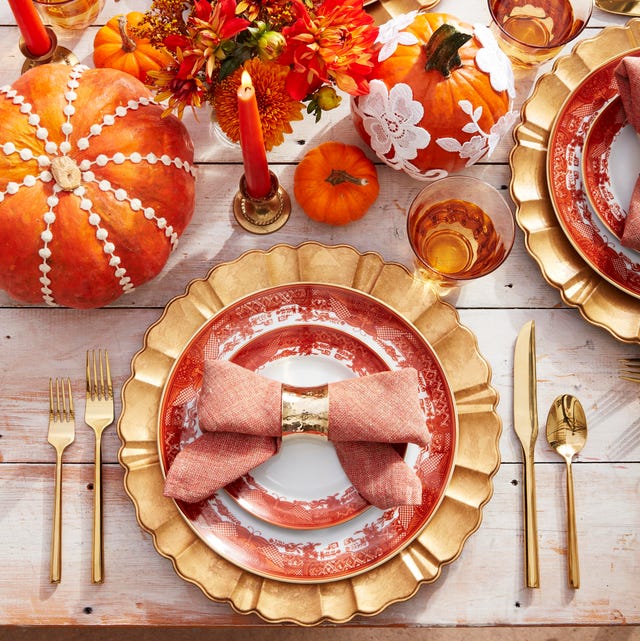 bowtie napkins on orange transferware plates with gold charger and flatware