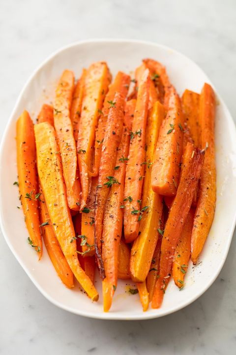 honey glazed carrots garnished with thyme on a white plate