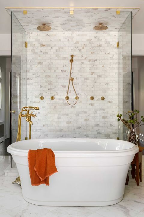 white bath tub with gold faucets and gold shower