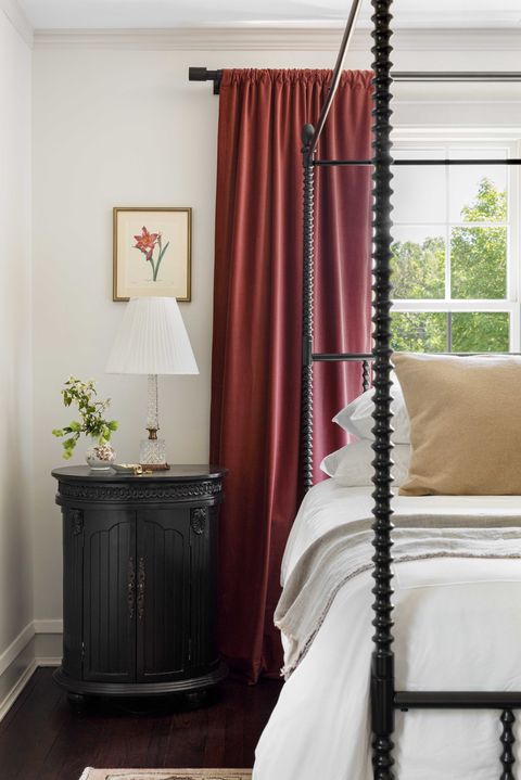main bedroom, red curtains, white bed with black bedframe and white linen, black side table