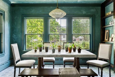 dining room with green walls, dark brown table with white countertop