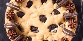 cookie cake with oreos mixed in and on top with chocolate frosting
