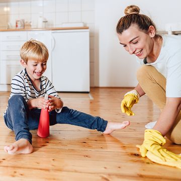 mom and son cleaning wood floors with spray bottle and rubber gloves