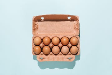 organic eggs in cartons tray on blue background flat lay, top view