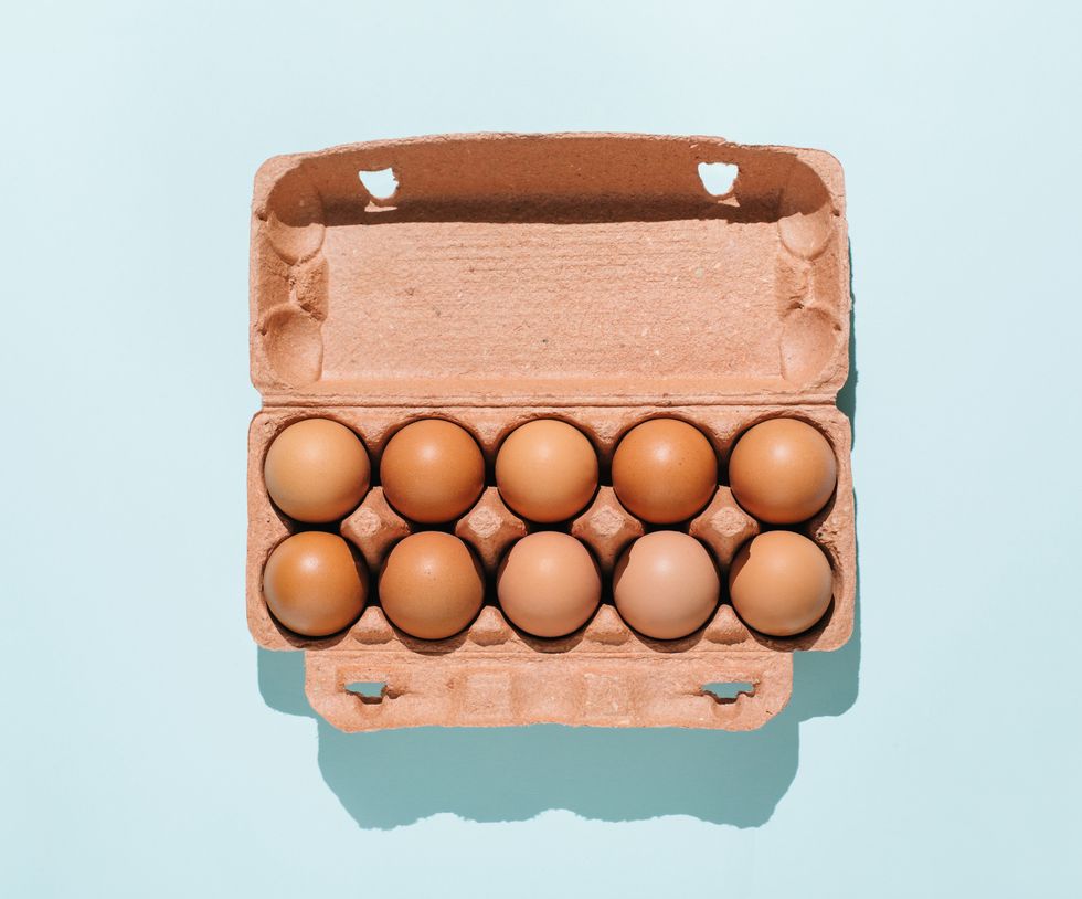 organic eggs in cartons tray on blue background flat lay, top view