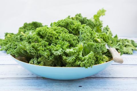 organic kale in a blue bowl on wood